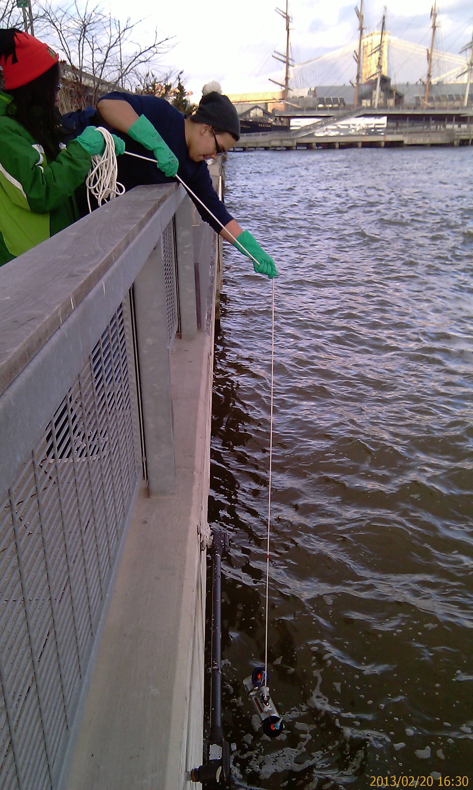 Tahirah and Orlando pull up their group's water sample from the East River