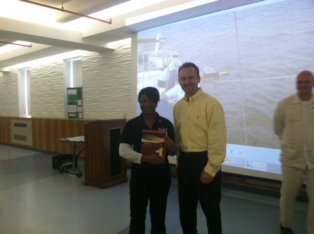Ameena receiving an ArcGIS tutorial book from Dave LaShell, ESRI