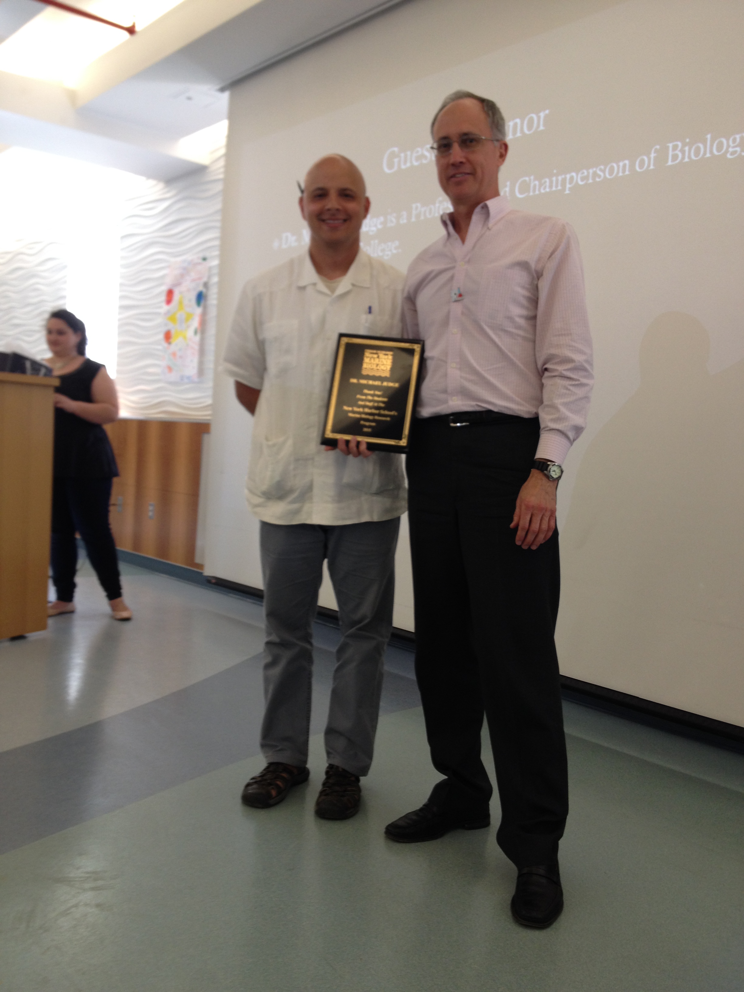 Dr. Michael Judge being presented a plaque by Mauricio Gonzalez in recognition of his longstanding collaboration with the Marine Biology Research Program 